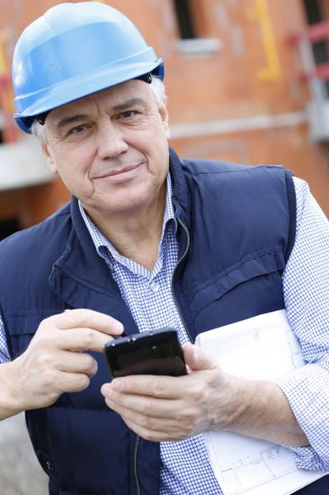 16320833 - entrepreneur on construction site using smartphone